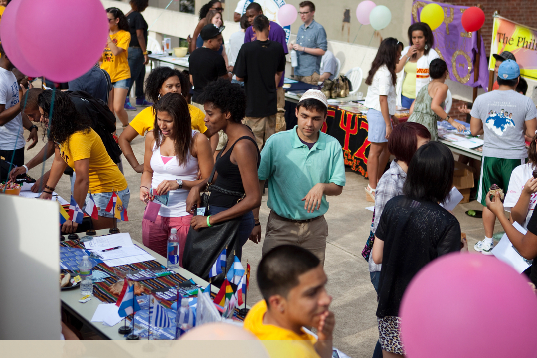 Diverse students at tables for an event on campus